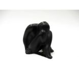 A Lalique figure of seated girl, black glass, crossed legs with face hidden, signed to base,