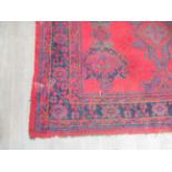 A large red Turkish carpet with multiple borders, areas of wear, 13' x 12' approx.