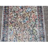 A modern hand made rug central field decorated with deer, tree blossoming plants and birds,