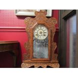 A wooden cased mantel clock with Roman numerated dial and carved front facie