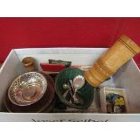 A small box containing a pair of plated wine bottle coasters, wooden dice shaker,