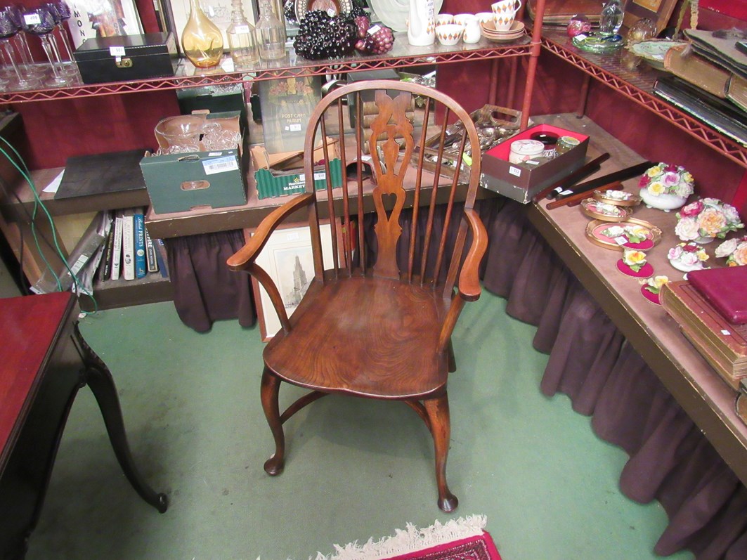 An elm and oak Windsor armchair the dished seat on cabriole legs and crinoline stretcher