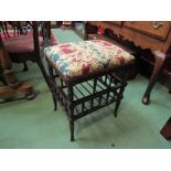 A late Victorian walnut piano stool on ring turned and spindle base with outswept feet