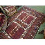 A red ground Eastern rug with multiple borders and tasselled end,