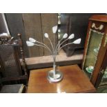 A metal base lamp with seven frosted glass spot shades, (plus two spare shades),