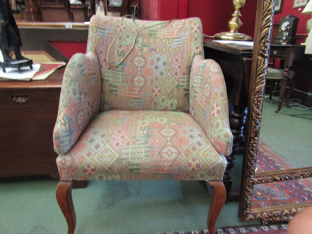 A mid 20th Century tub chair on sabre legs and enclosed arms with contemporary upholstery