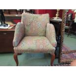 A mid 20th Century tub chair on sabre legs and enclosed arms with contemporary upholstery