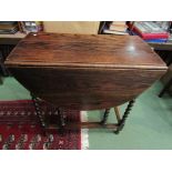 An oak drop-leaf gate-leg table on barley-twist supports,