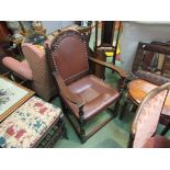 An 18th Century style carved oak master's armchair with copper studs and leather upholstery on