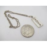 A silver ingot on chain and a 1976 silver American dollar