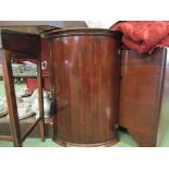 A George III style mahogany bow front wall hanging single door corner cupboard of small proportions