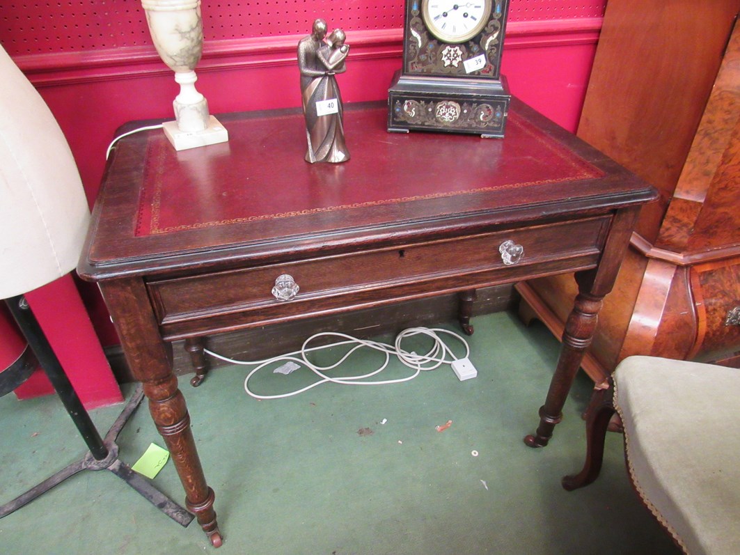 A mid Victorian oak writing desk the tooled leather inset over a single frieze drawer with key on