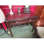 A mid Victorian oak writing desk the tooled leather inset over a single frieze drawer with key on