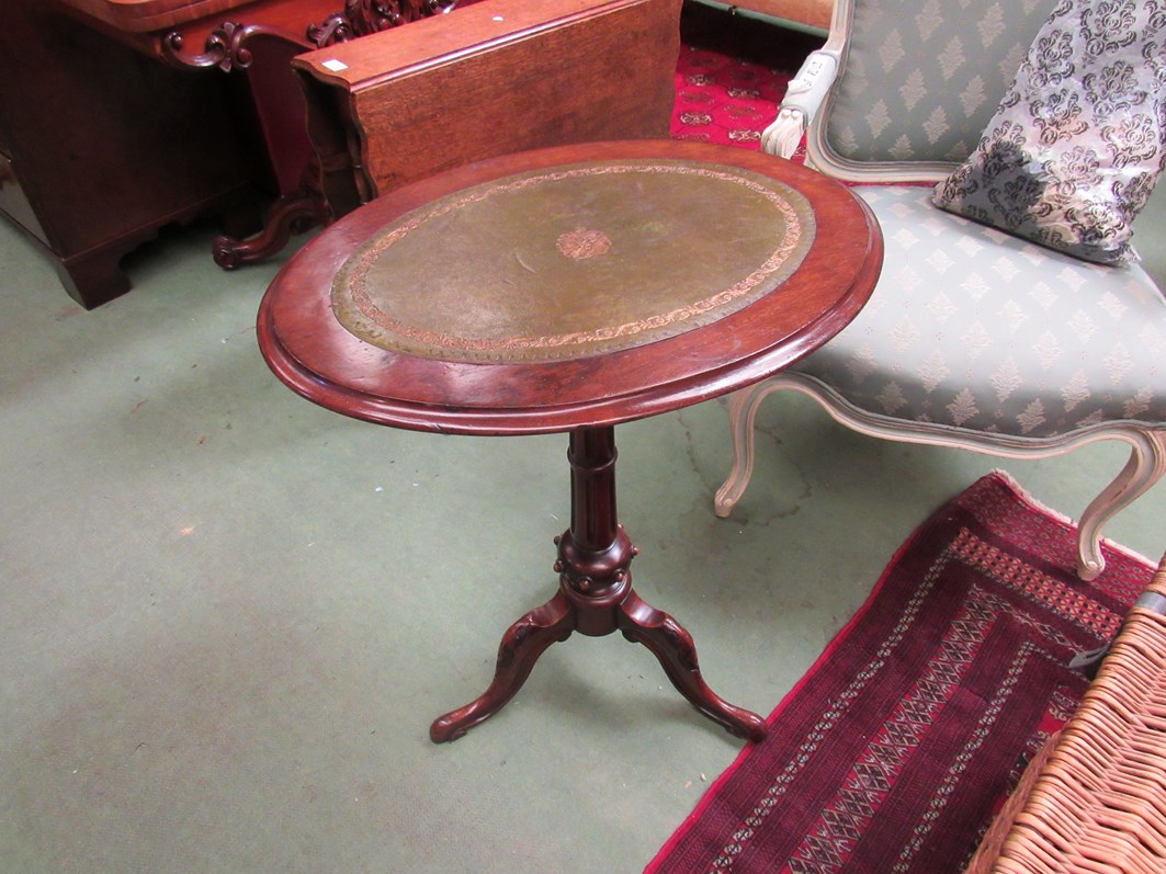 A Victorian walnut oval top wine table with gilt tooled leather inset on a turned column and tripod