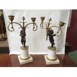 A pair of 19th Century bronze putti holding aloft ormulu twin sconces,