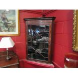 An Edwardian mahogany wall hanging corner cabinet with satinwood stringing and astragal glazing,