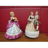 Two 1940's wind-up musical figures of a couple and a girl with a cat