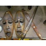 A pair of African tourist ware masks and two paddles,