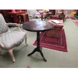 A Victorian lacquered circular tilt-top wine table on turned baluster column and tripod base with
