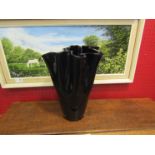 A wavy edged dark glass vase,