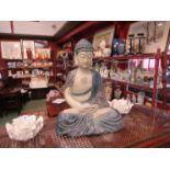A carved seated buddah in blue tones,