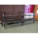 A Bavarian style carved and dark stained oak open back two tier plate rack decorated with winged