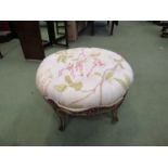 A 19th Century button seat painted circular stool with carved floral decoration on sabre legs,