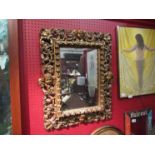 A gilt distressed effect rococo style framed mirror, 65cm x 50cm approx.