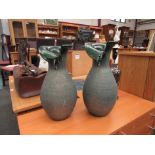 A pair of terracotta bulbous form vases with green iridescent style effect with flared form necks