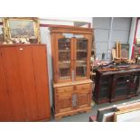 A pine dresser with glazed door top, shelved interior, two drawers and two cupboard doors below,