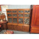 A pair of early 20th Century oak stacking bookcases with leaded panelled doors over cupboard bases,