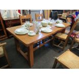 A modern oak extending dining table and a set of six (4+2) ladder back rush seated chairs