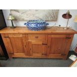 A modern pine large side cabinet of three cupboard doors and a single drawer, ironwork fittings,