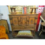 An Old Charm style oak cupboard with carved doors and two frieze drawer,