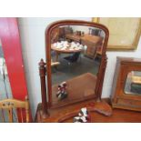 A Victorian mahogany swivel mirror with reeded columns,