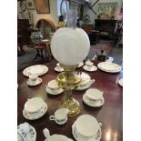 A brass oil lamp with globular shade