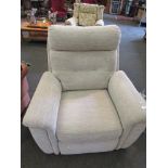 An electric reclining armchair with beige upholstery