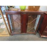 A Regency style astragal glazed display cabinet with twin doors, bracket feet,