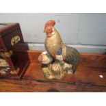 An Oriental glazed pottery figural group of a cockerel and chicken on stump, 25.
