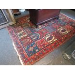 A Persian rug in reds, blues and ochre,