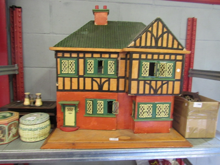 A 1950's two storey dolls house as a timber frame building with tinplate windows,