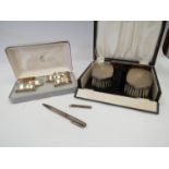 A cased set of six silver oval form napkin rings together with a cased pair of silver brushes,
