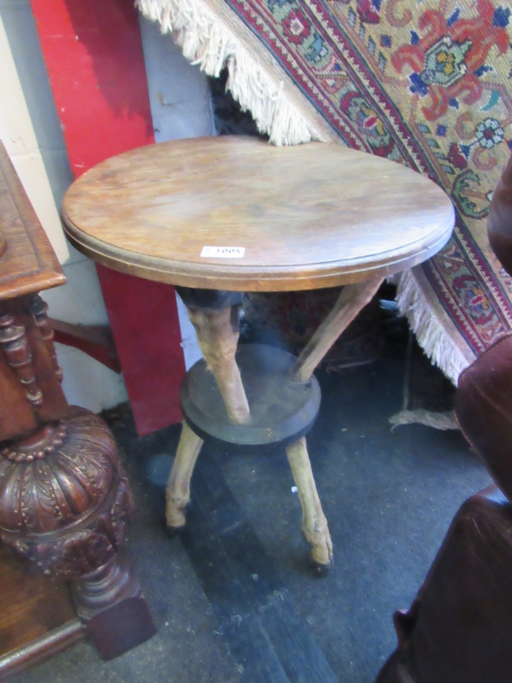 A circular top table supported by deer legs, 48cm diameter,