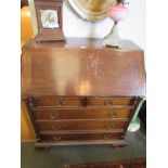 A mahogany bureau, reeded columns, two over three drawer base, carved bracket feet,