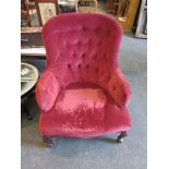 A pair of Victorian button back armchairs in deep red velvet upholstery,