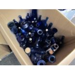 A box containing a quantity of blue glass bottles, vases,