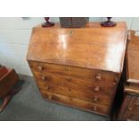 An elm bureau the drop down top with fitted interior and well over a four graduated drawer base,