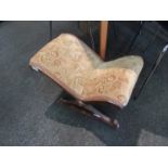 A walnut gout stool with foliate design upholstery