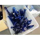 A box containing a quantity of mostly blue glass bottles,