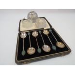 A cased set of six silver coffee bean spoons and match strikers including silver rimmed